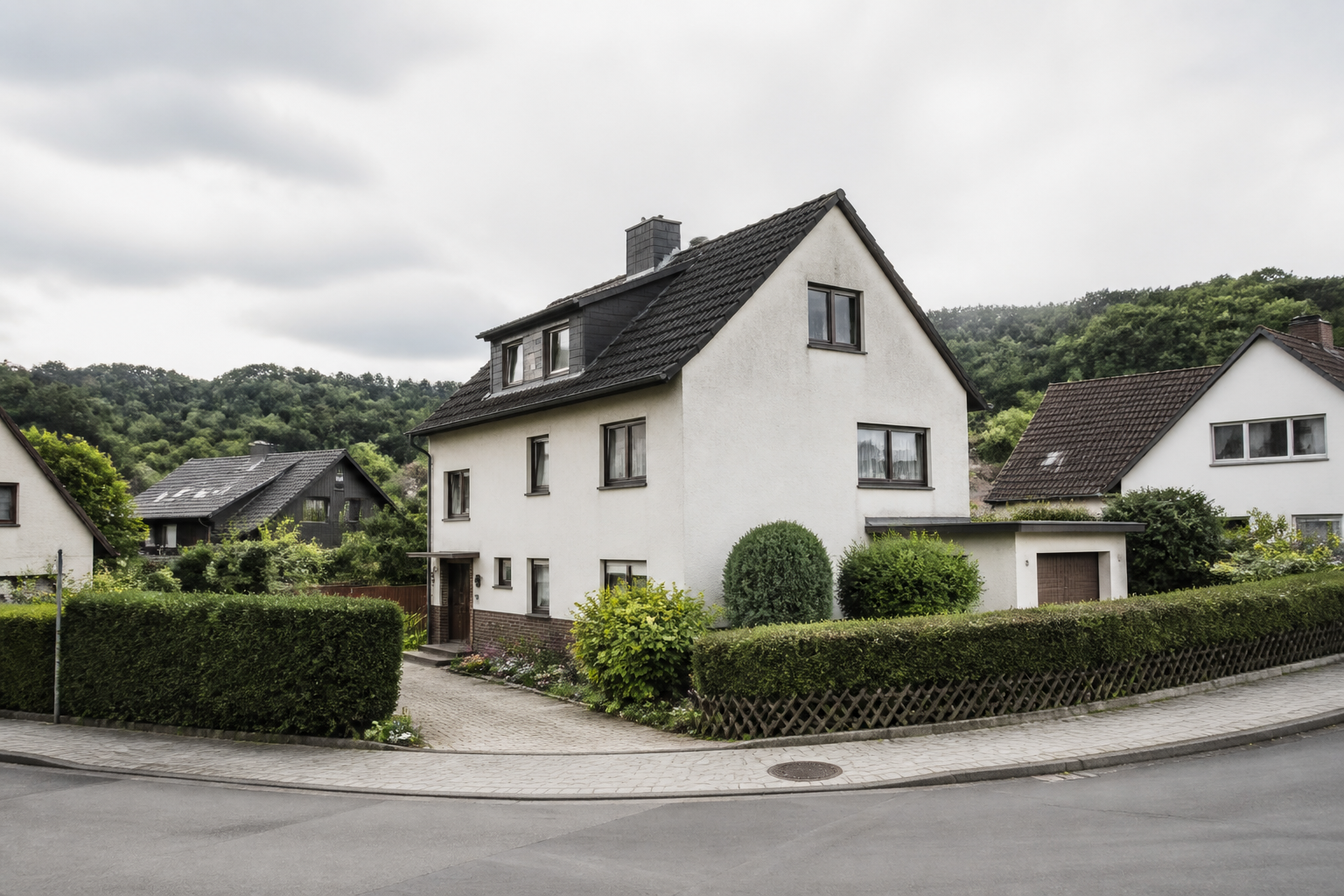 Gewöhnliches Wohnhaus mit Garten in einer grünen, hügeligen Wohnlage.